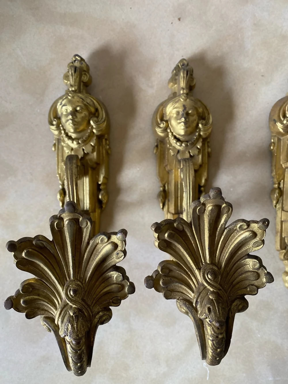 Two ornate bronze wall sconces on a marble surface available to buy from the-salon.com. SALON curates the finest unique handmade pieces from the interior industry's best makers and brands. Shop luxury furniture, lighting, rugs, art, antiques and vintage pieces and accessories from SALON interior designed rooms.