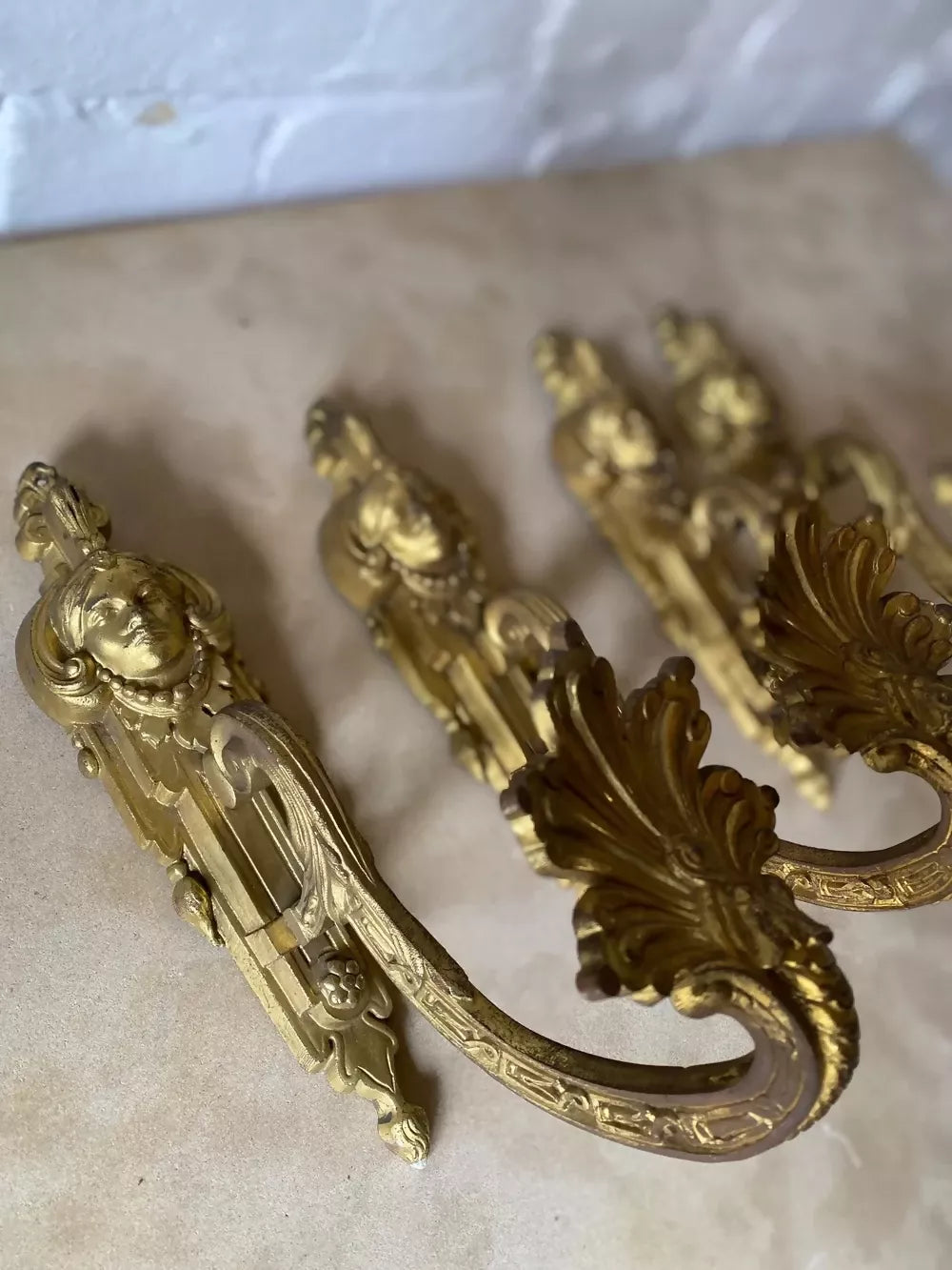 Two ornate bronze wall sconces on a marble surface available to buy from the-salon.com. SALON curates the finest unique handmade pieces from the interior industry's best makers and brands. Shop luxury furniture, lighting, rugs, art, antiques and vintage pieces and accessories from SALON interior designed rooms.